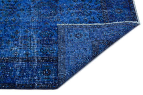 Load image 1 in gallery view. Deep blue distressed rug with a traditional floral medallion pattern and a folded corner showing the underside.