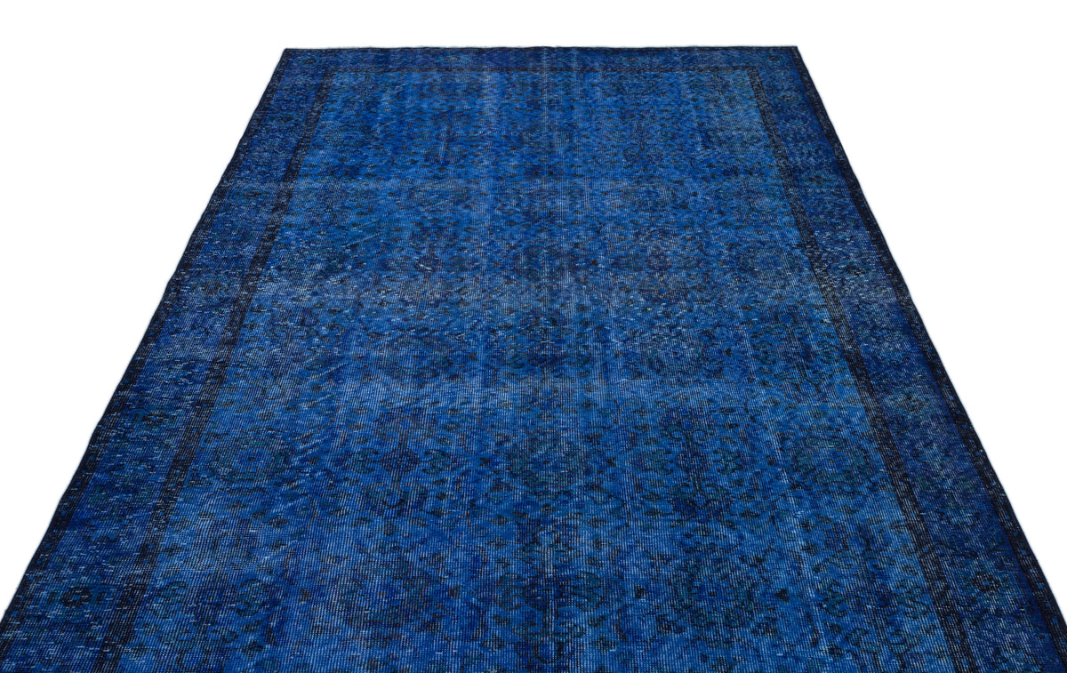 Deep blue vintage-style rug with a distressed, intricate floral medallion pattern and a dark border.