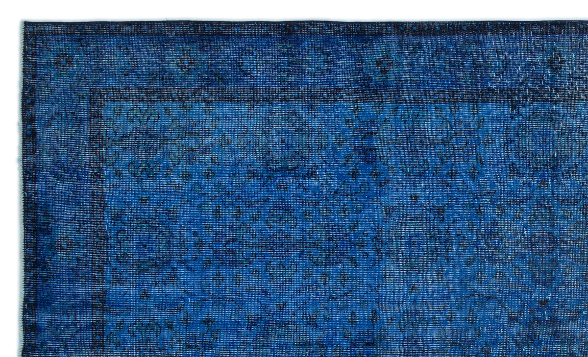 Deep blue distressed rug with a subtle, dark floral medallion pattern and a bordered edge.