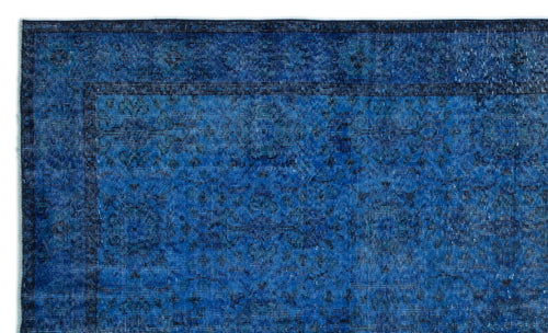 Load image 1 in gallery view. Deep blue distressed rug with a subtle, dark floral medallion pattern and a bordered edge.