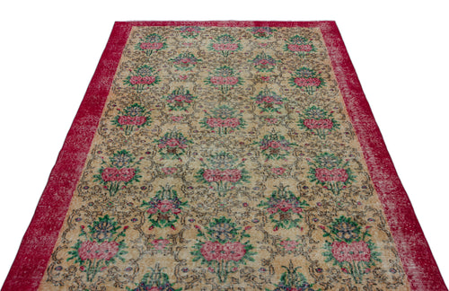 Load image 1 in gallery view. Beige vintage-style rug with a repeating floral pattern in pink and green, framed by a wide, distressed red border.