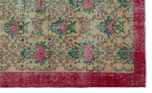 Load image 1 in gallery view. Tan rug with a repeating floral medallion pattern in pink, green, and blue, featuring a wide red border.