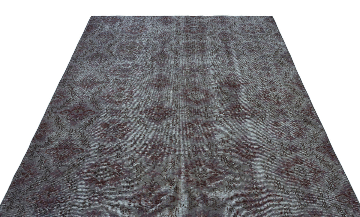 Distressed charcoal and burgundy rug with a repeating traditional medallion pattern on a white background.