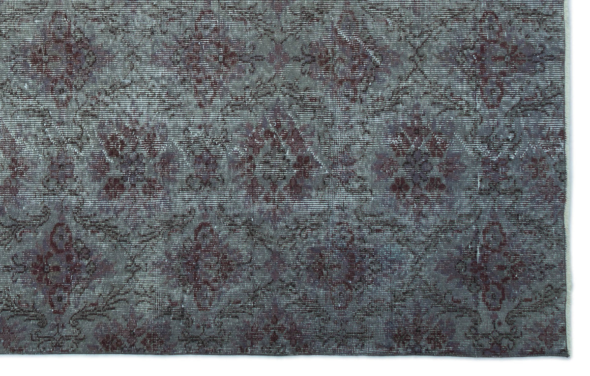 Distressed charcoal and deep red rug with a repeating floral medallion pattern.