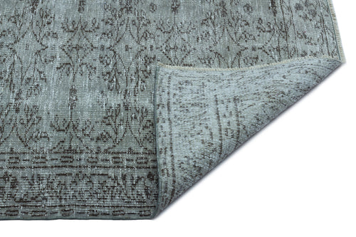 Load image 1 in gallery view. Grey and brown distressed vintage-style rug with a floral medallion pattern, shown with a corner folded over.
