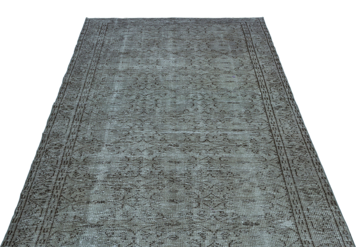 Grey and brown vintage-style rug with a distressed traditional medallion pattern and a bordered edge.