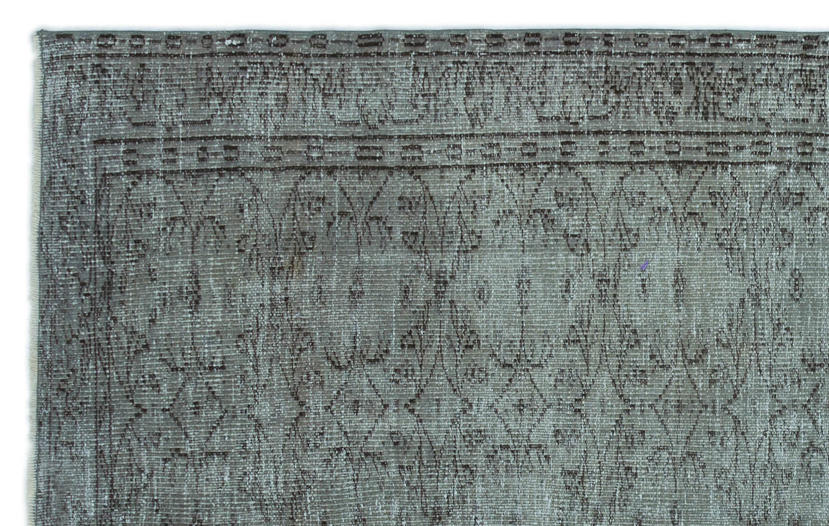 Sage green and dark brown distressed rug with a traditional lattice and floral border pattern.
