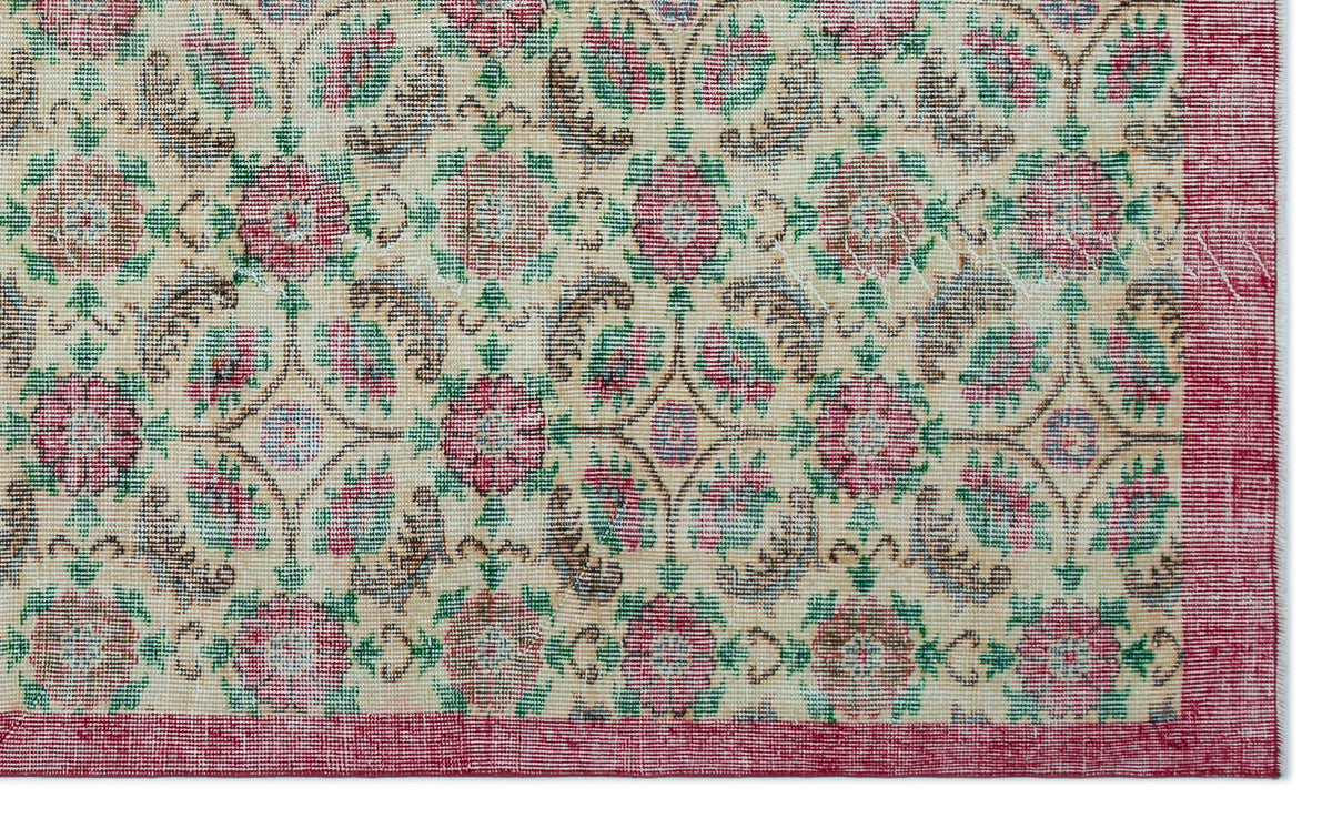 Cream rug with a repeating floral medallion pattern in red, green, and brown, featuring a solid red border.