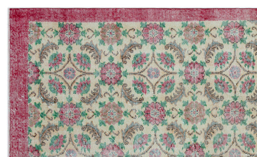 Load image 1 in gallery view. Cream rug with a red border and a repeating floral medallion pattern in red, green, and brown.