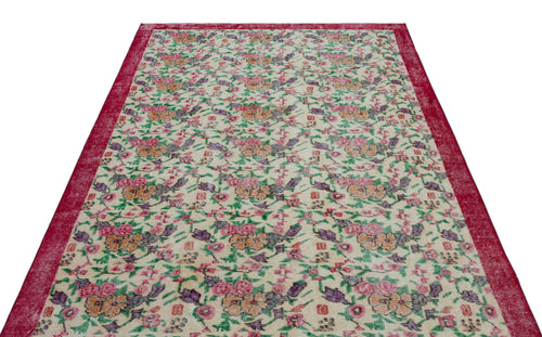 Load image 1 in gallery view. Cream rug with a red border and a repeating floral pattern in pink, orange, purple, and green.