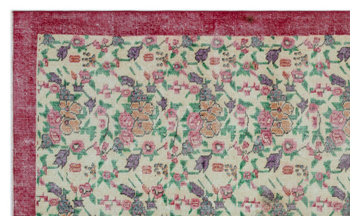 Load image 1 in gallery view. Cream rug with a red border and a repeating floral pattern in pink, purple, orange, and green.