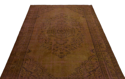 Load image 1 in gallery view. Distressed brown vintage rug with a central dark medallion and ornate floral border on a white background.