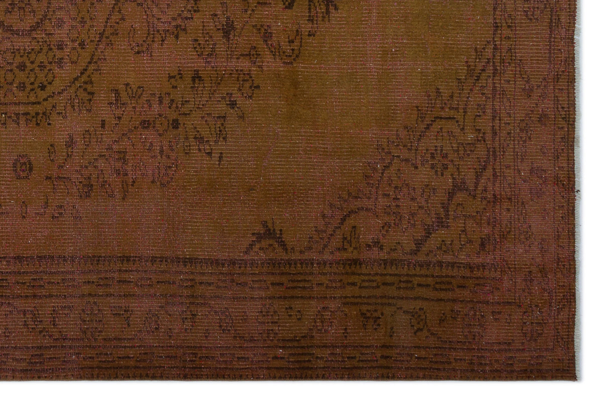 Dark brown vintage-style rug with a faded black floral medallion pattern and a detailed border.