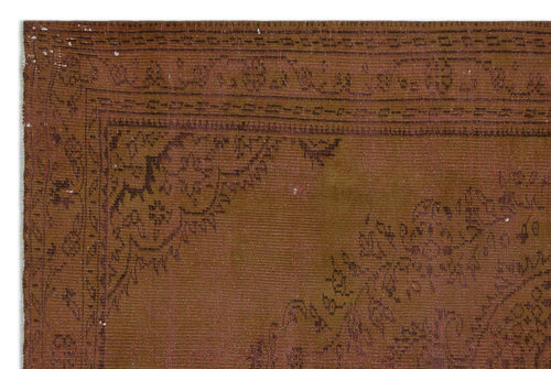 Load image 1 in gallery view. Brown vintage-style rug with a dark, faded floral medallion pattern and a geometric border.