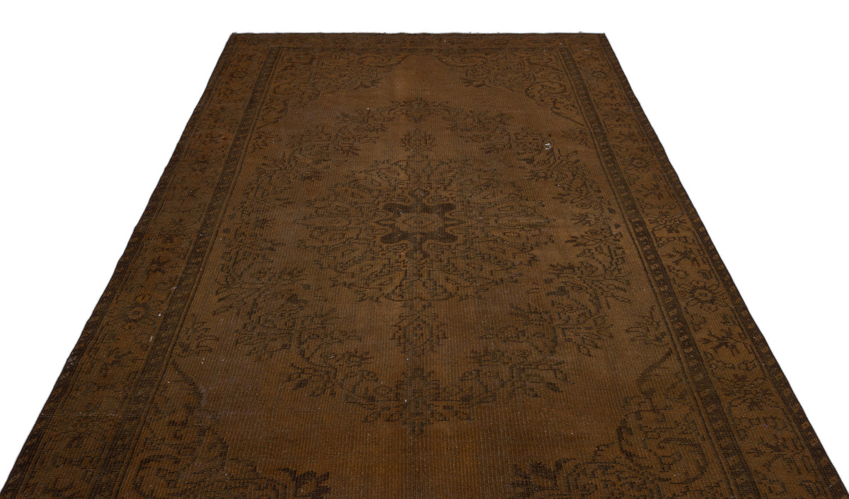 Monochromatic dark brown rug with a traditional central medallion and ornate floral border on a white background.