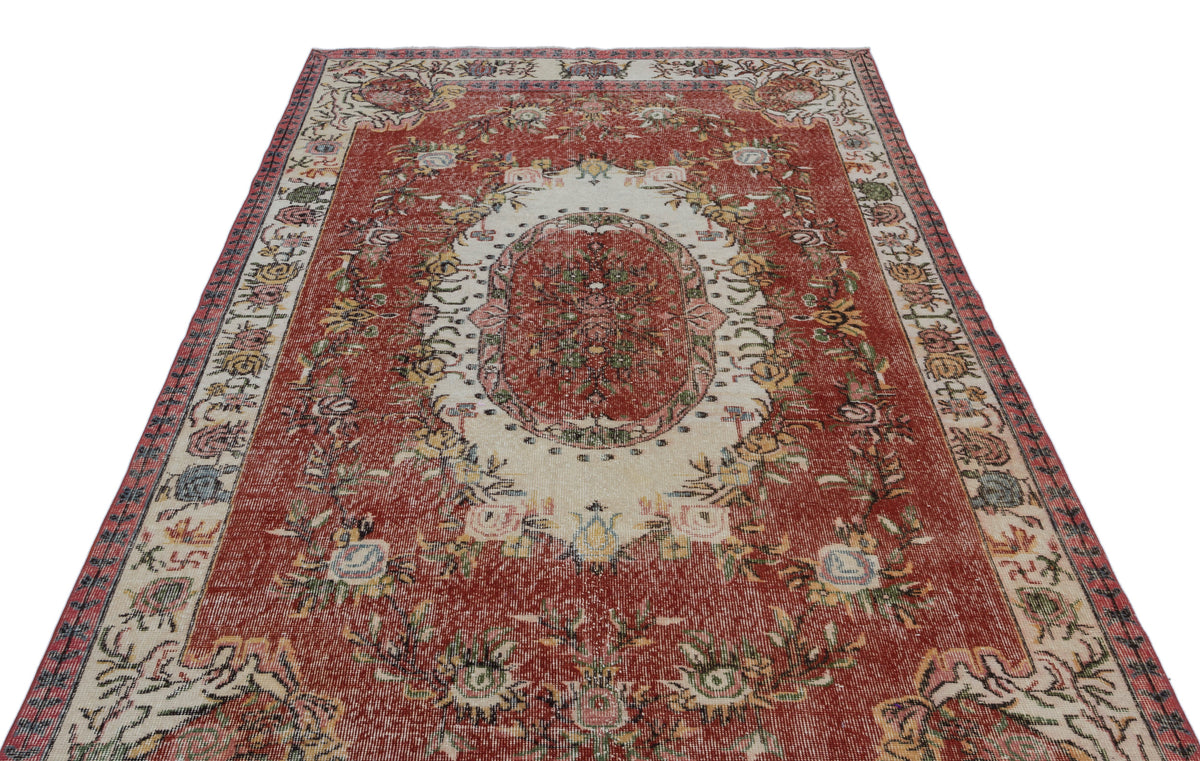 Red and cream traditional rug with a central floral medallion and intricate botanical border patterns.