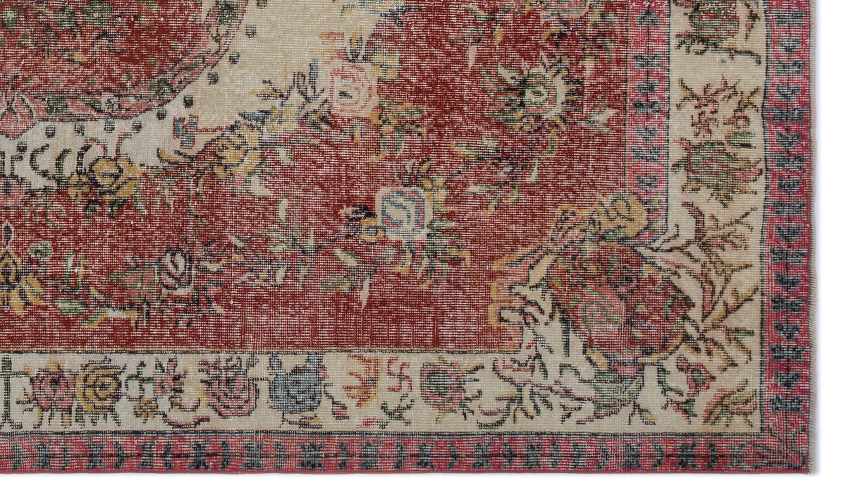 Distressed red and cream traditional rug with a floral medallion pattern and a decorative border.