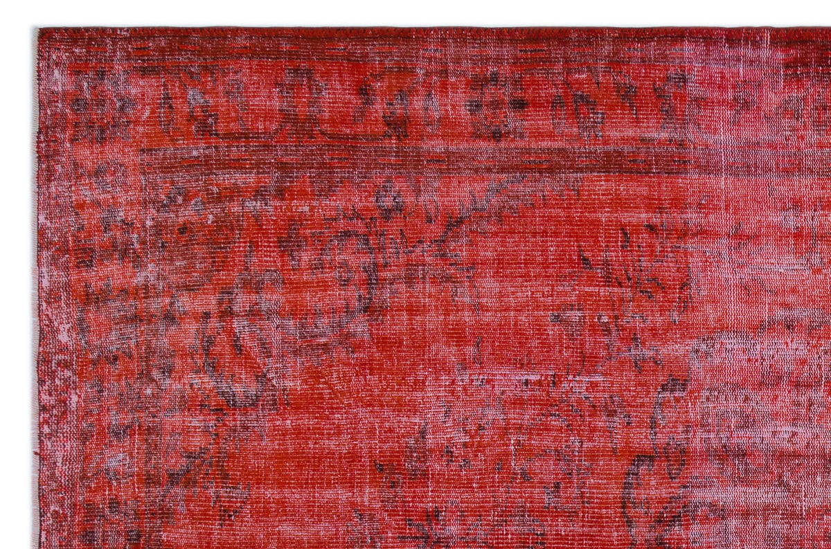 Distressed red and dark pink rug with a faded traditional floral medallion pattern.