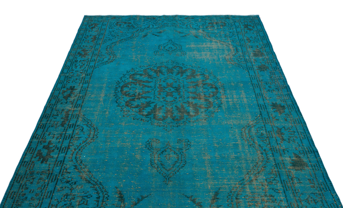 Teal vintage-style rug with a distressed black central medallion and ornate border pattern on a white background.