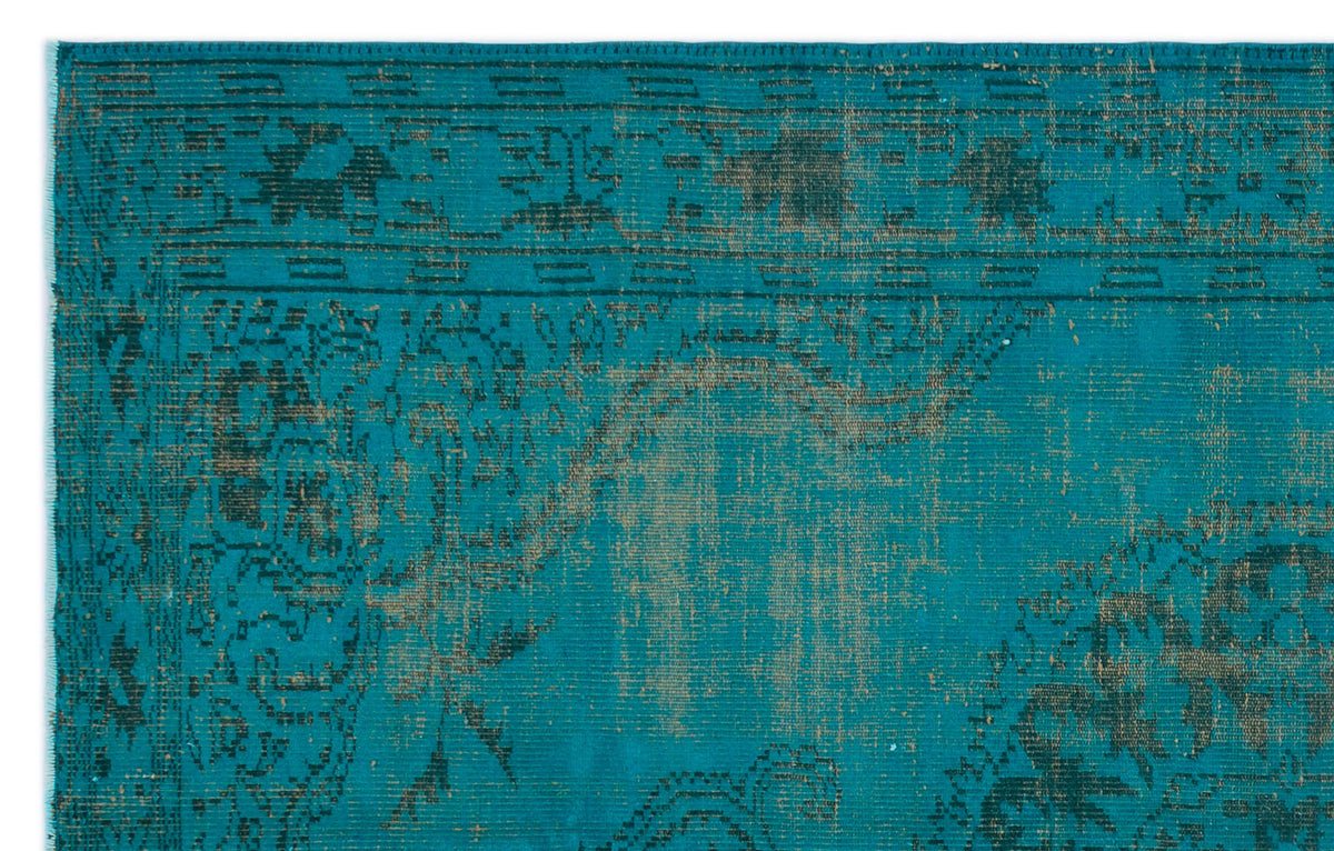 Teal and dark charcoal distressed rug with a faded traditional medallion pattern.