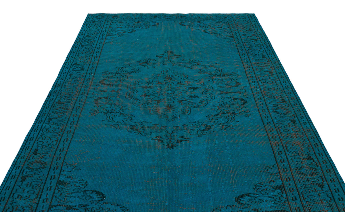 Teal distressed rug with a dark charcoal central medallion and ornate border pattern on a white background.