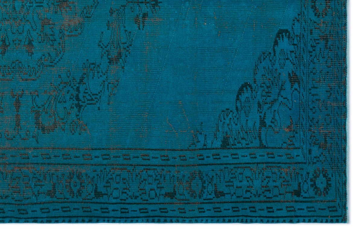 Teal rug with a dark, distressed traditional floral medallion pattern and a geometric border.