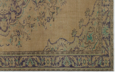 Load image 1 in gallery view. Tan vintage-style rug with a distressed floral medallion pattern in dark blue and teal accents.