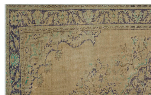 Load image 1 in gallery view. Tan vintage-style rug with a distressed dark blue and teal floral border and central medallion pattern.