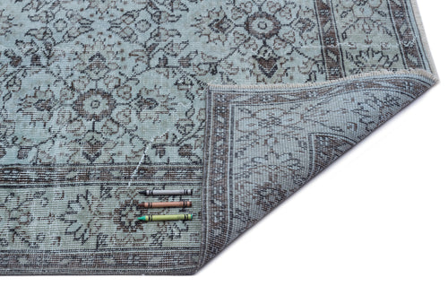 Load image 1 in gallery view. Light blue and brown distressed traditional medallion rug with a folded corner, isolated on a white background.