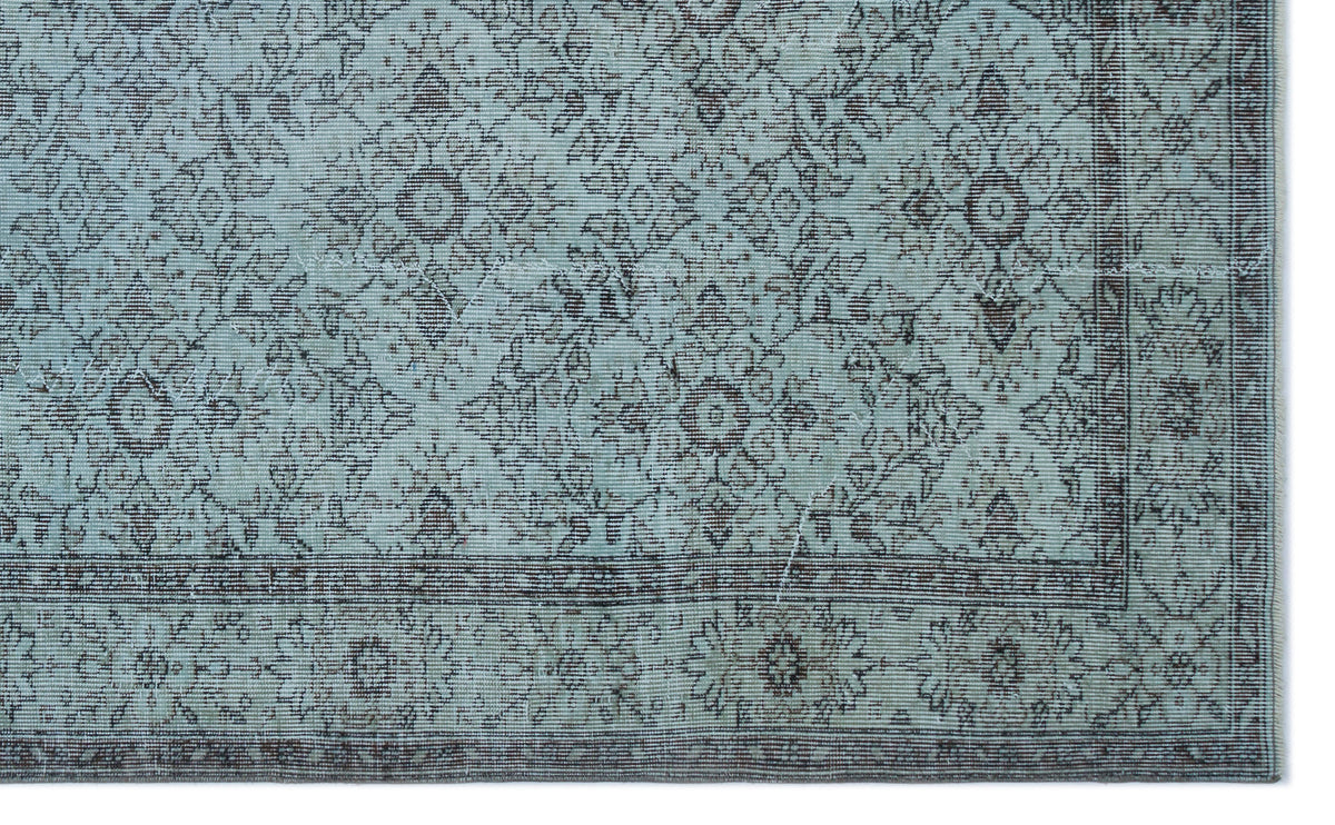 Light blue rug with a dark brown traditional floral medallion pattern and a detailed border.