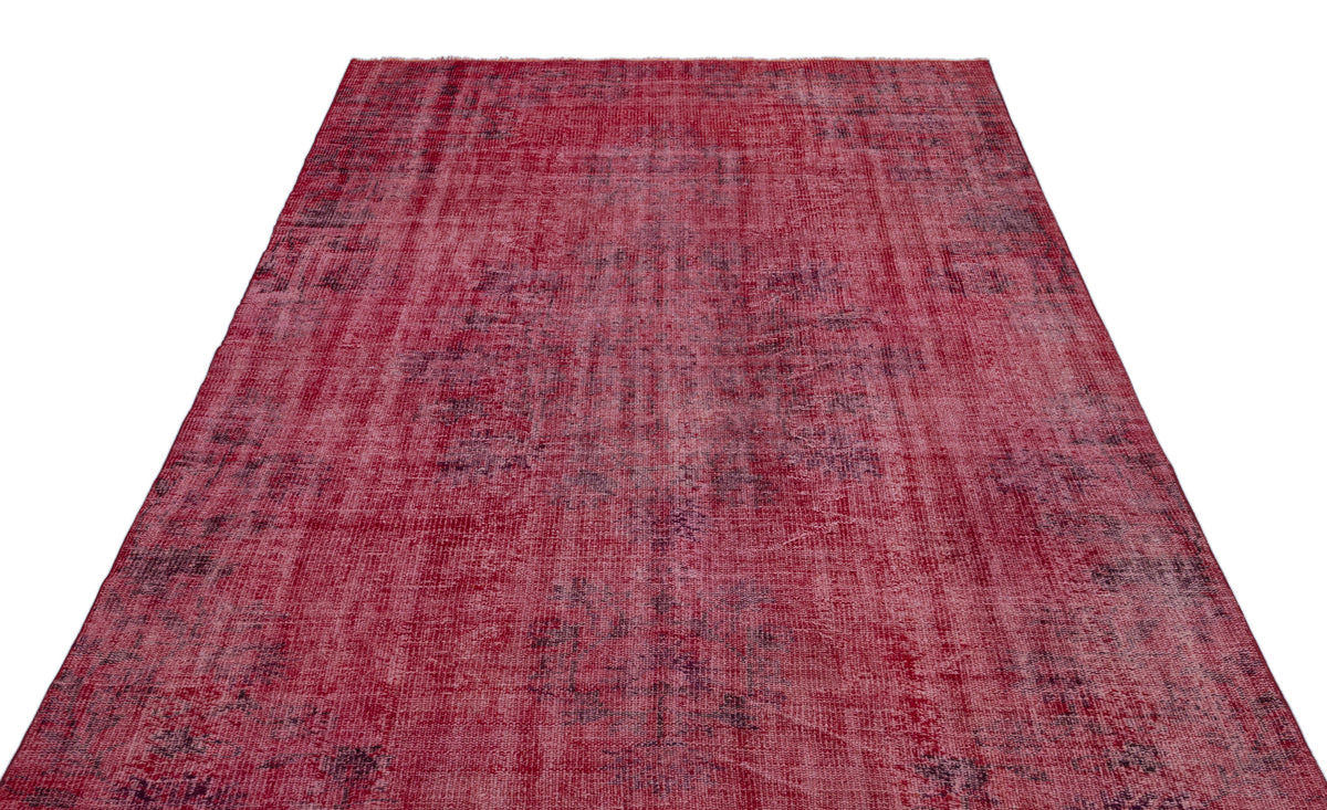 Deep red and magenta distressed area rug with a faded, traditional overdyed pattern on a white background.