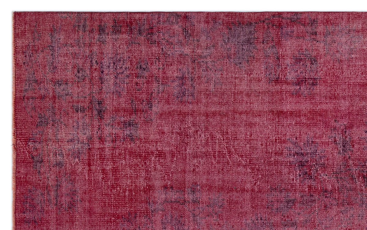 Magenta and deep purple distressed rug with a faded, abstract overdyed pattern.