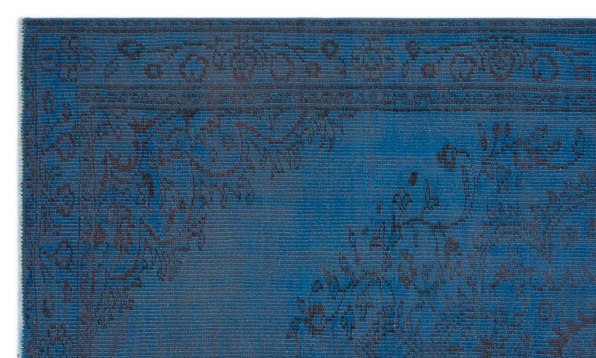 Deep blue rug with a dark charcoal floral medallion pattern and a detailed geometric border.
