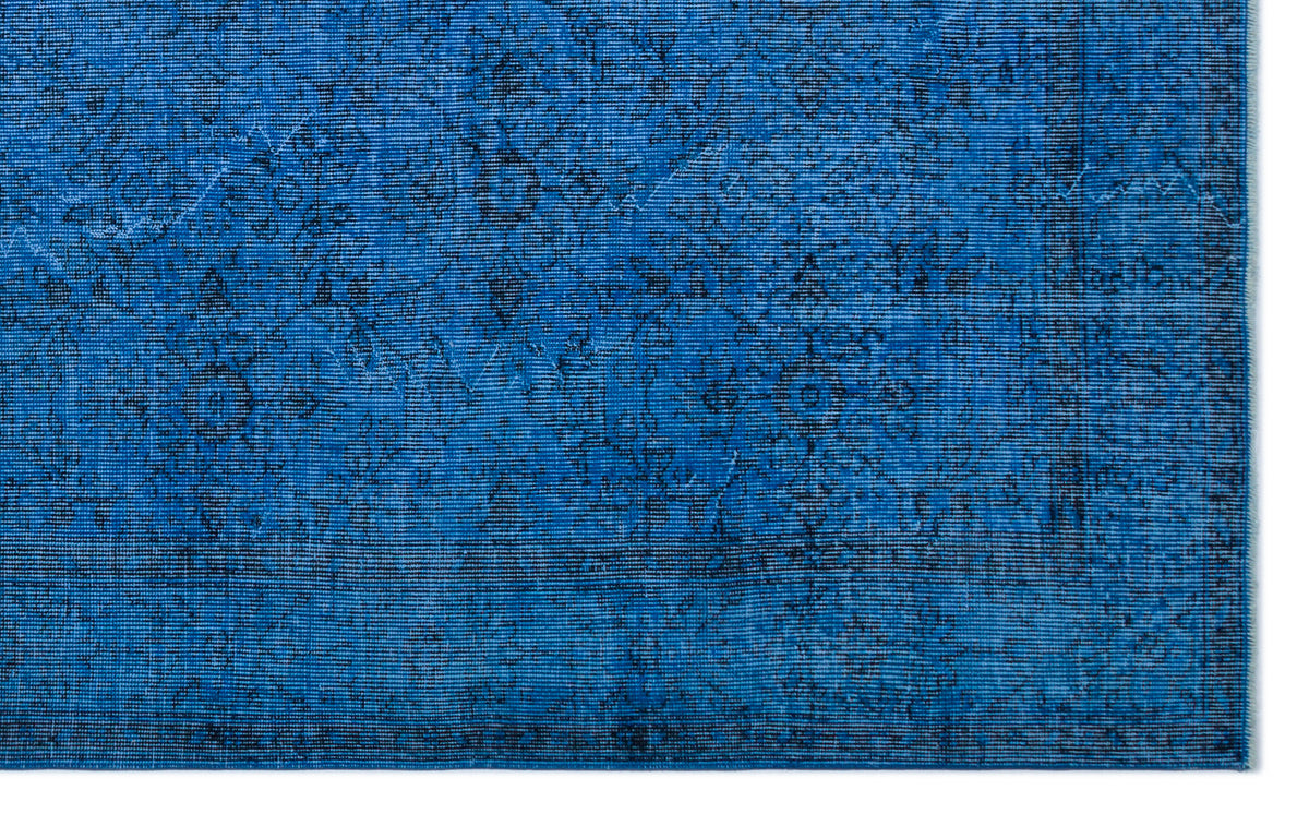 Vibrant blue rug with a distressed, dark-toned traditional floral medallion pattern and a bordered edge.