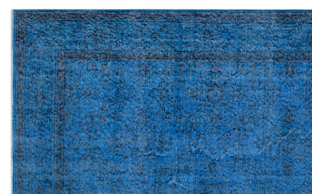 Bright blue rug with a black distressed traditional floral medallion pattern and a bordered edge.