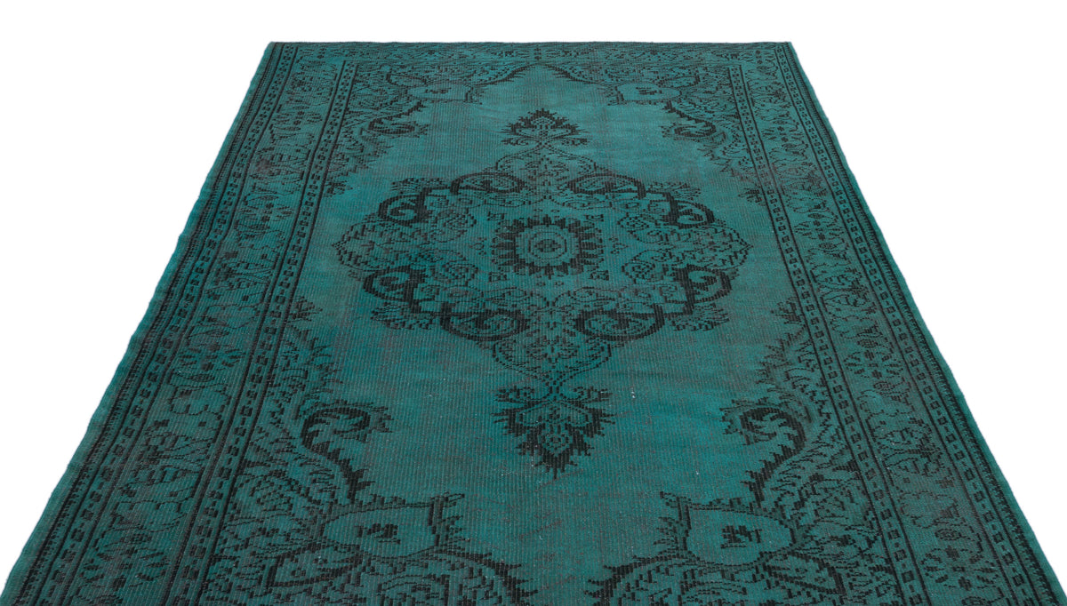Teal and black distressed rug with a traditional central medallion and ornate border pattern.