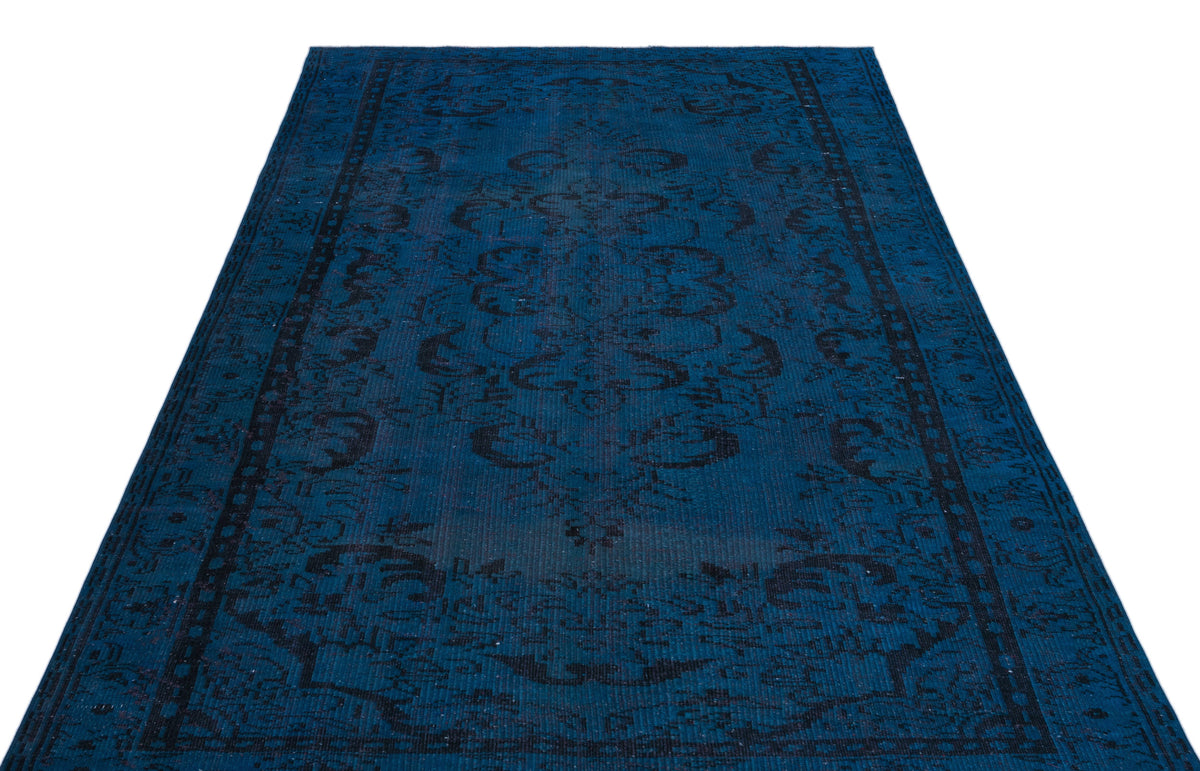 Deep blue distressed rug with a black traditional floral medallion pattern on a white background.