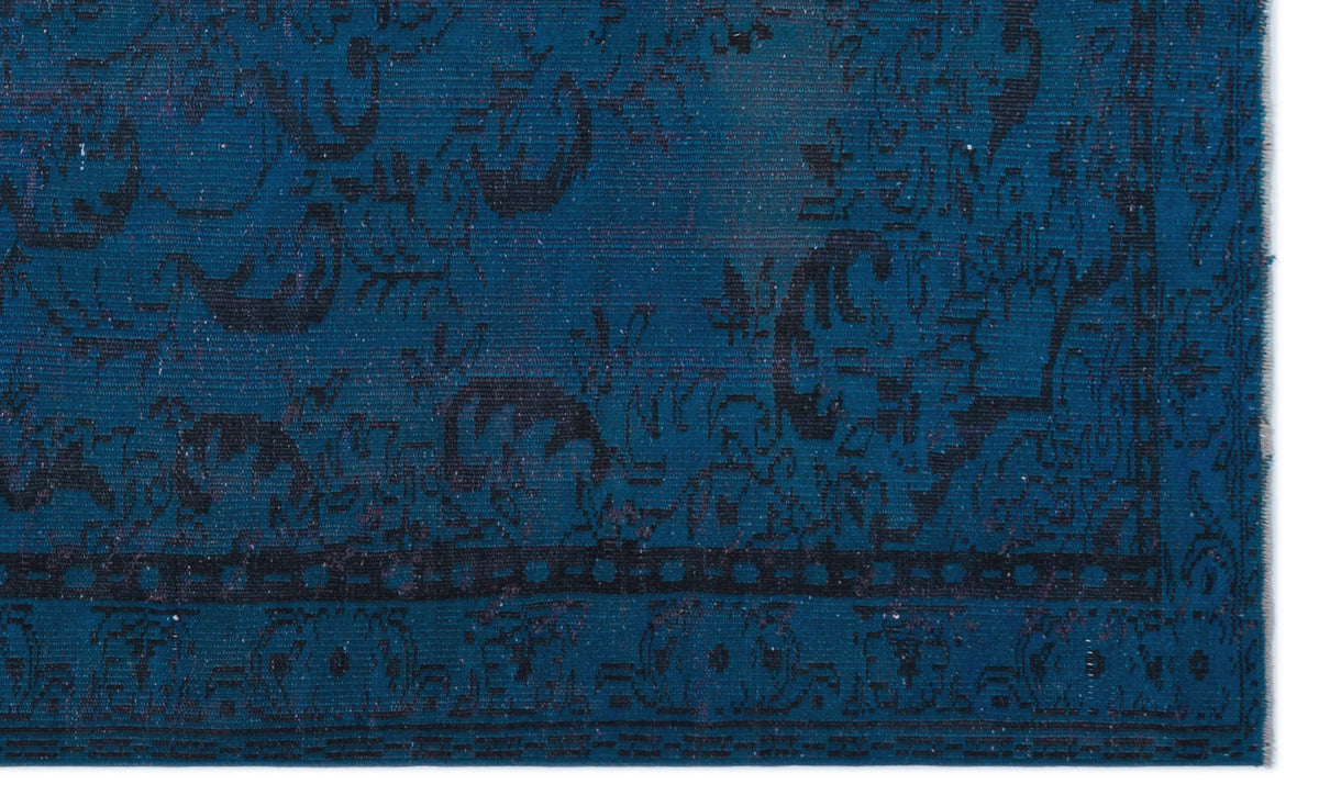 Deep blue rug with a black distressed traditional floral pattern and a geometric border.