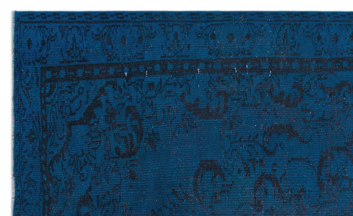 Deep blue rug with a black distressed traditional medallion pattern and a geometric border.