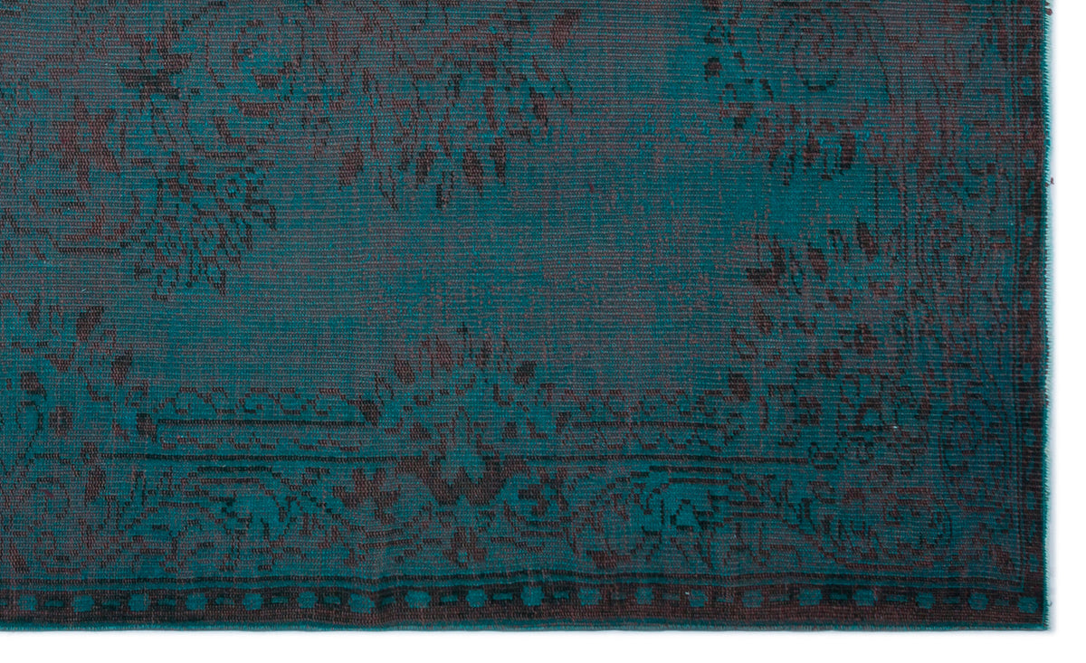 Teal and charcoal rug with a distressed, traditional floral medallion pattern and a geometric border.