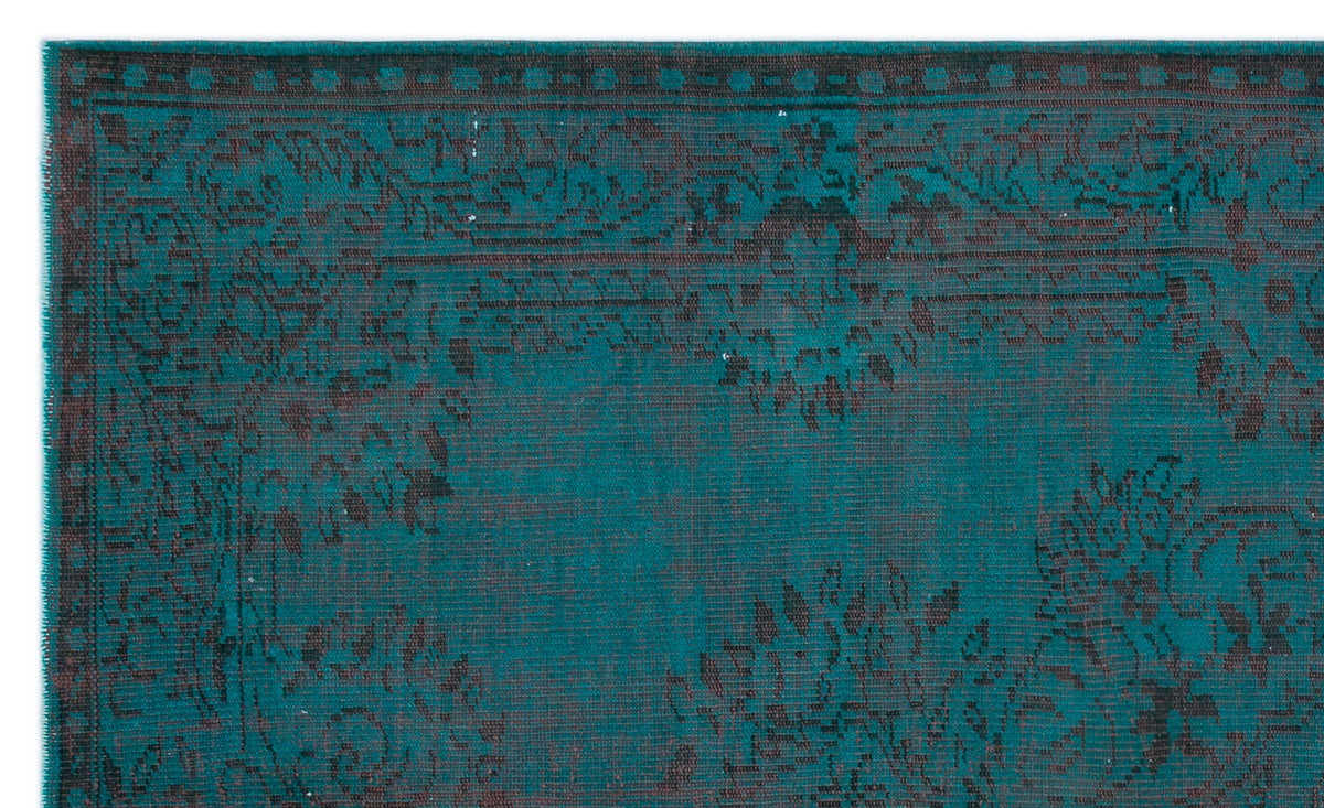 Teal and black distressed rug with a traditional floral medallion pattern and a geometric border.
