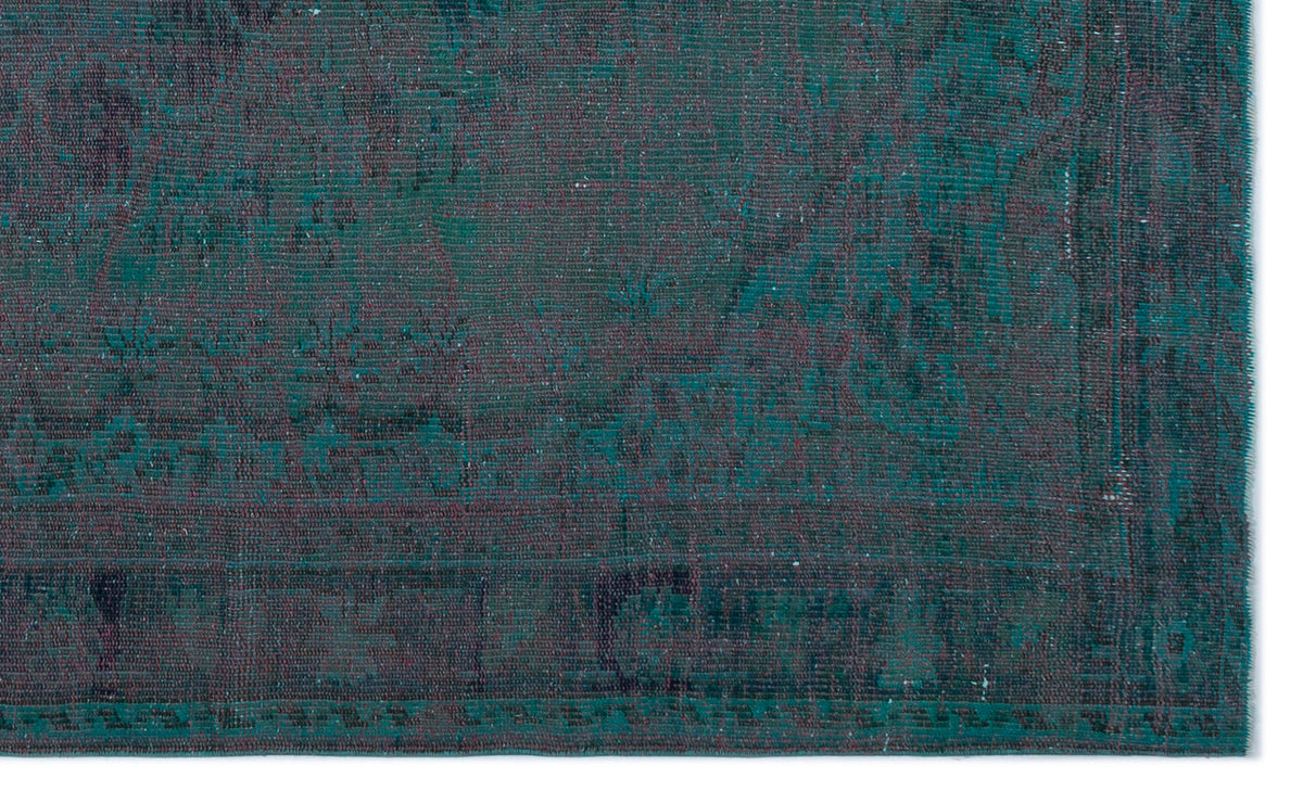 Teal and dark purple distressed rug with a faded traditional medallion pattern on a white background.