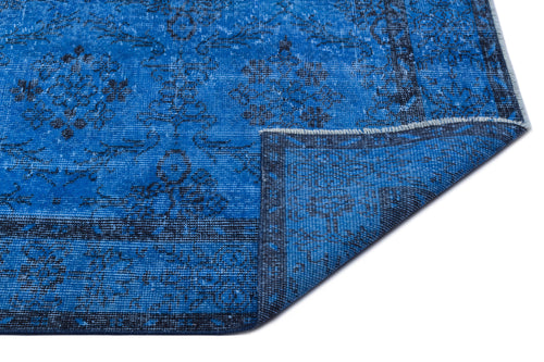 Bild 1 in Galerieansicht laden. Bright blue rug with a distressed black floral medallion pattern and a folded corner, isolated on a white background.