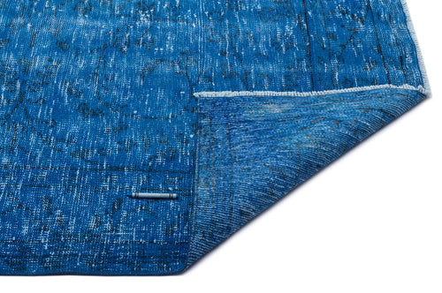 Load image 1 in gallery view. Distressed blue rug with a faded black traditional pattern and a folded corner, isolated on a white background.