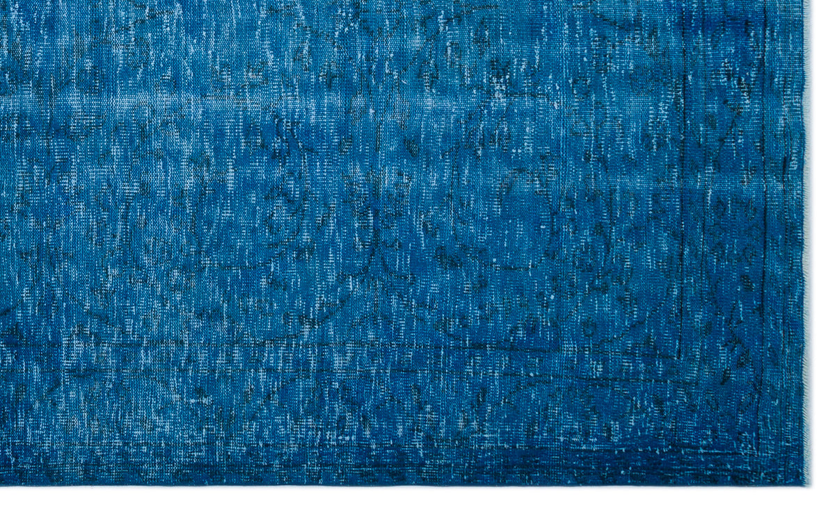 Deep blue distressed rug with a faint, traditional medallion pattern and a bordered edge.