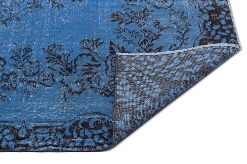 Load image 1 in gallery view. Blue and black distressed floral rug with a folded corner revealing the dark backing.