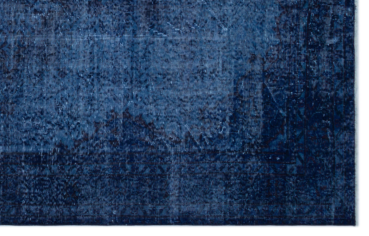 Deep blue distressed rug with a faded traditional medallion pattern and geometric border.