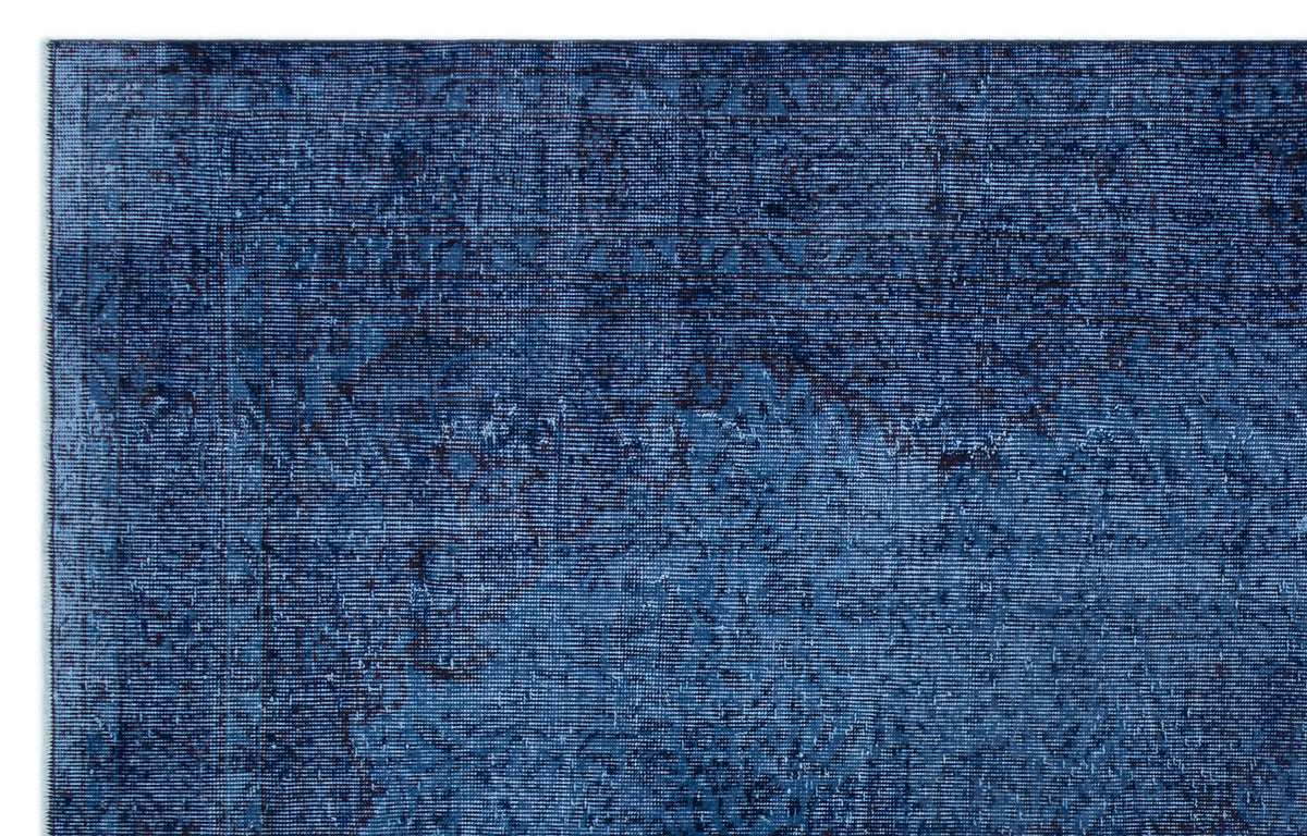 Deep blue distressed rug with a faint, traditional Persian-style medallion pattern.