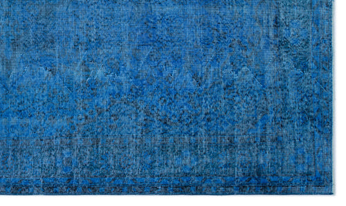 Load image 1 in gallery view. Bright blue distressed rug with a subtle, faded geometric medallion pattern and dark navy textured detailing.