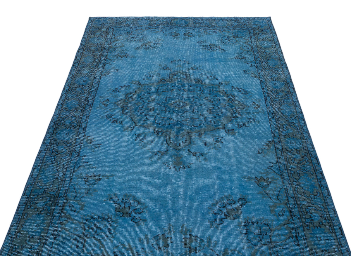 Bright blue distressed rug with a dark grey traditional floral medallion and border pattern on a white background.
